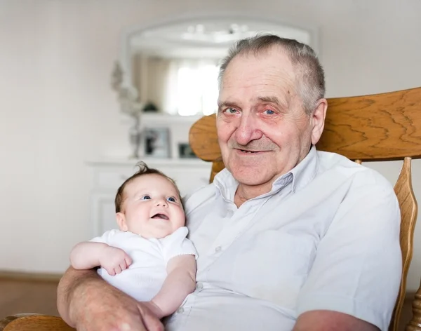 Morfar håller en nyfödd flicka — Stockfoto