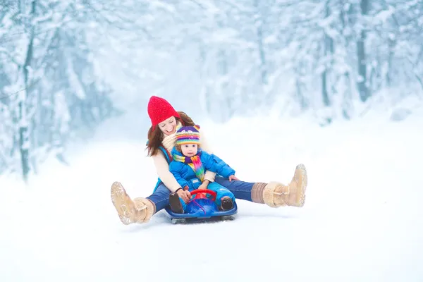 Mother and her little toddler daughter enjoying a sledge ride — Stock Photo, Image
