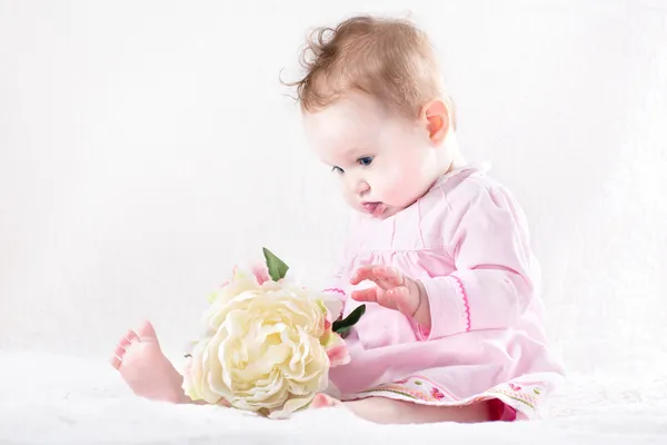 Menina bebê brincando com uma grande flor — Fotografia de Stock