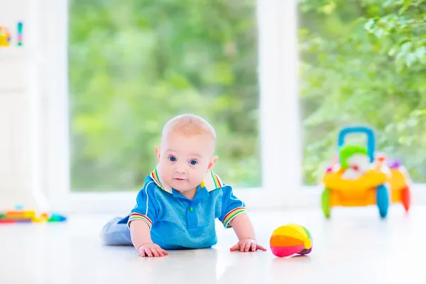 Adorabile bambino che gioca con una palla colorata e auto giocattolo — Foto Stock