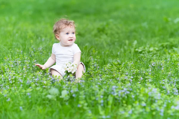 Meisje van de baby spelen met gele bloemen — Stockfoto