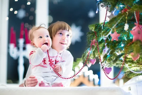 Brother and his baby sister at a Christmas tree — Stock Photo, Image
