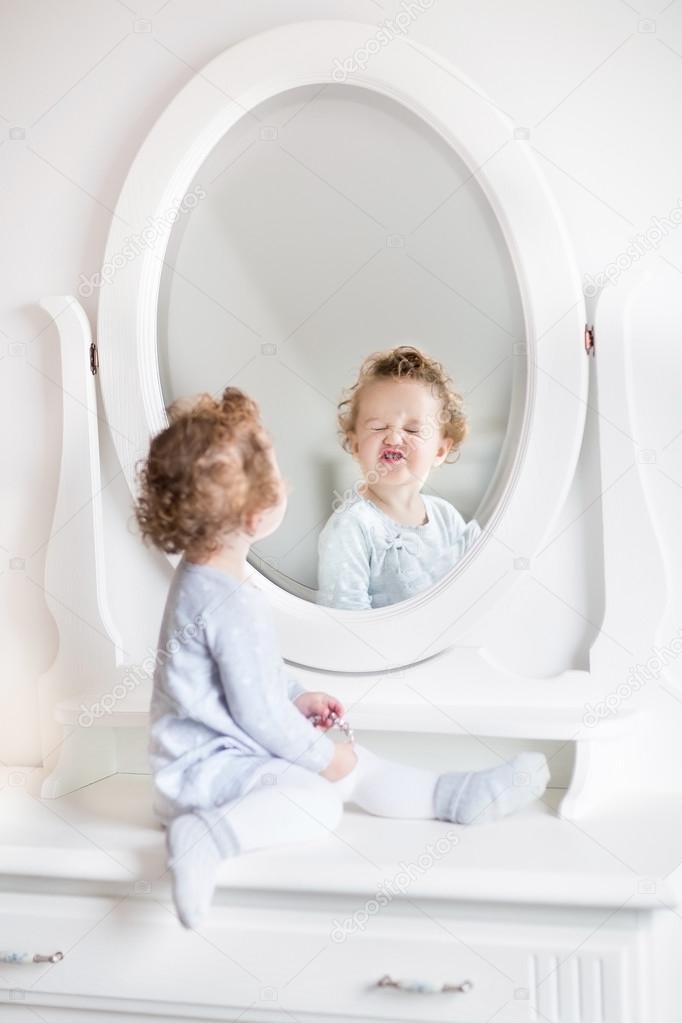 Baby girl looking at her reflection in a round mirror Stock Photo by ©FamVeldman 43250317 Baby girl looking at her reflection in a round mirror Stock Photo by ©FamVeldman 43250317