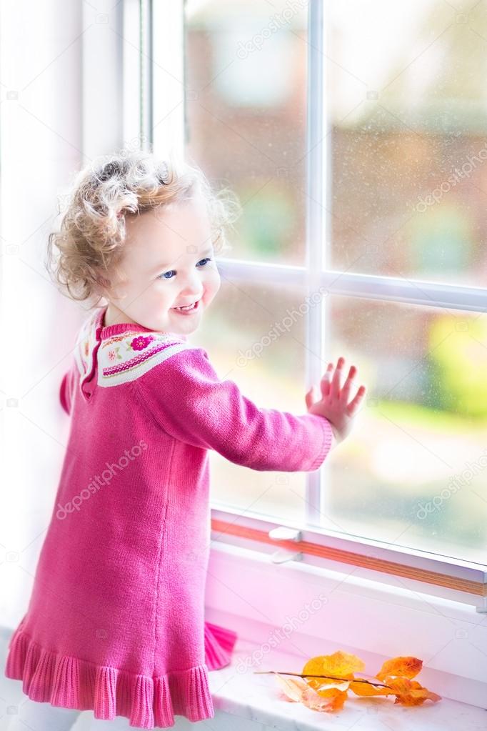 Toddler girl watching out of the window