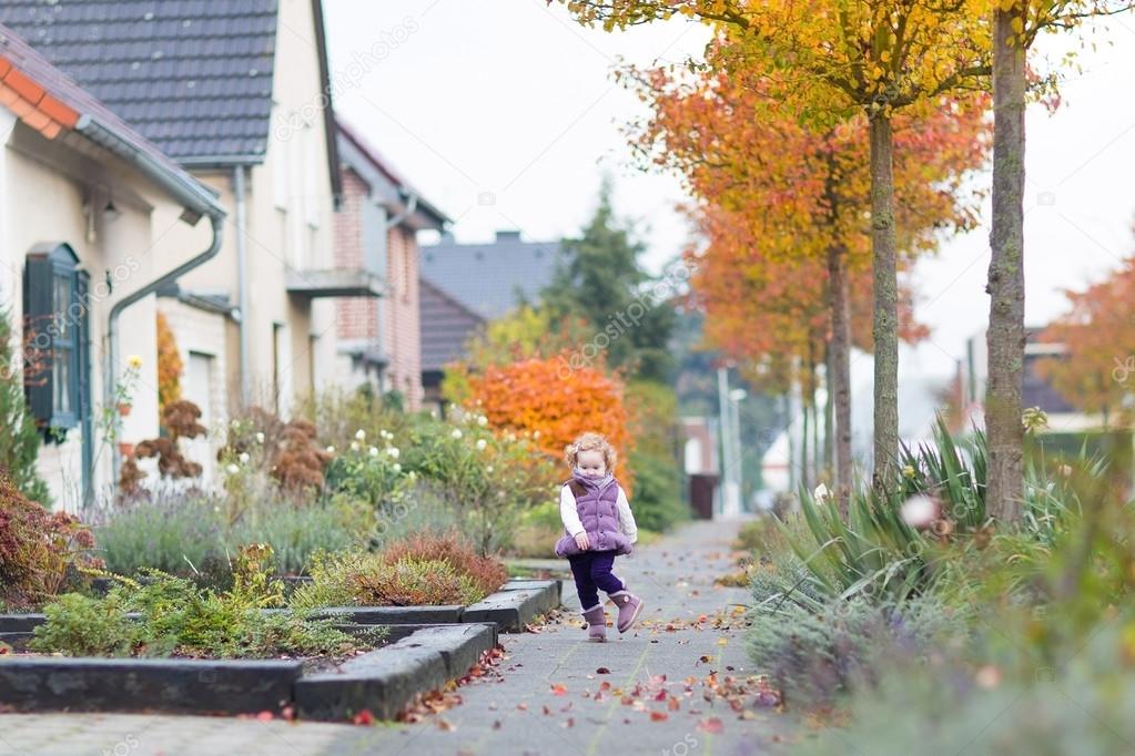 toddler girl walking down a road in a little German village