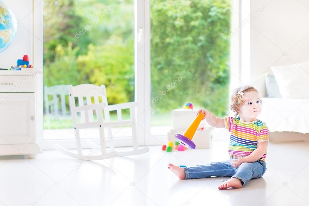 Toddler girl playing with a pyramid toy