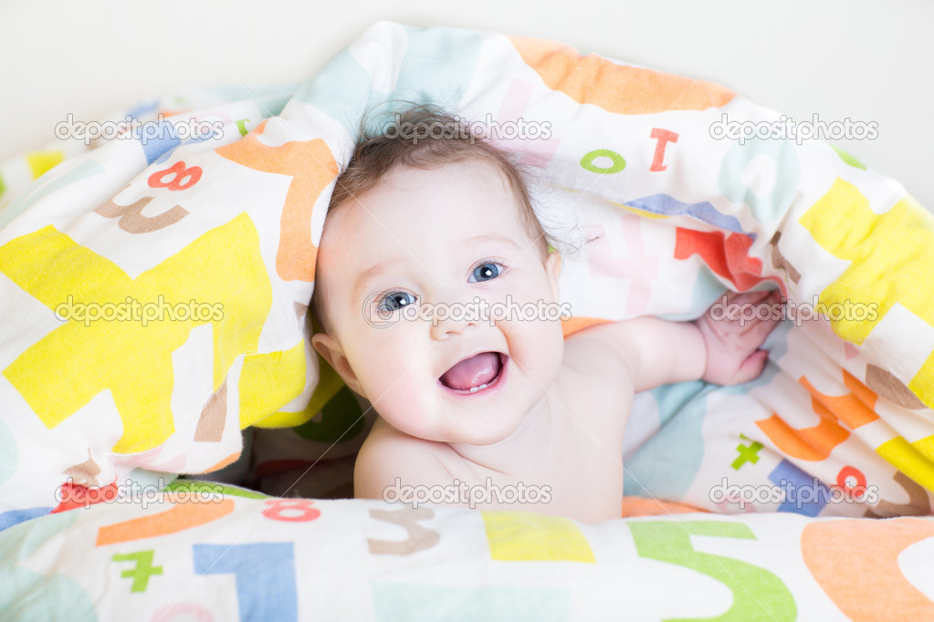 Baby under a colorful blanket