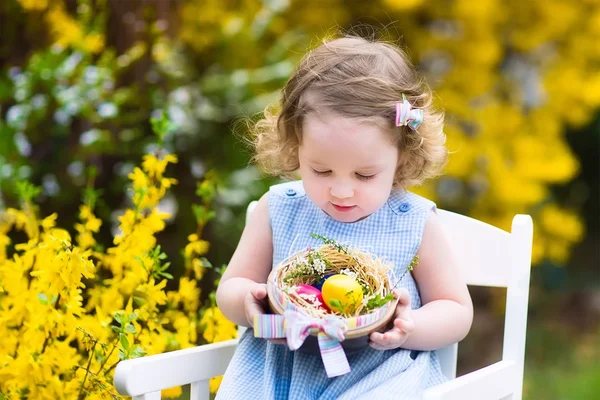 Linda niña rizada disfrutando de la caza del huevo de Pascua en el jardín —  Fotos de Stock