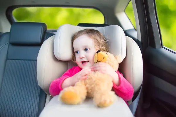 Linda niña en un asiento de coche durante el viaje de vacaciones — Foto de Stock