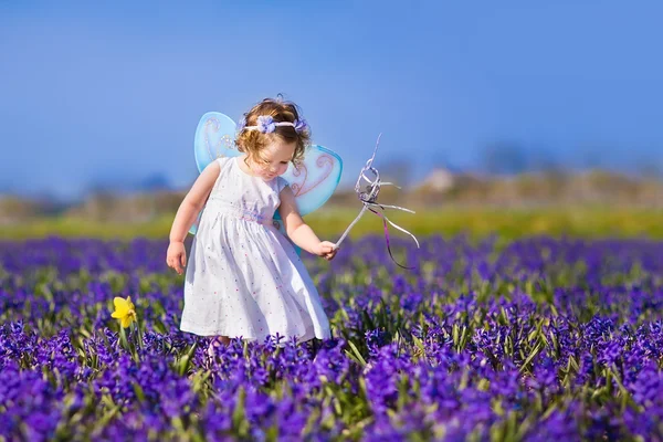 Cute toddler girl in fairy costume in a flower field — Stock Photo, Image