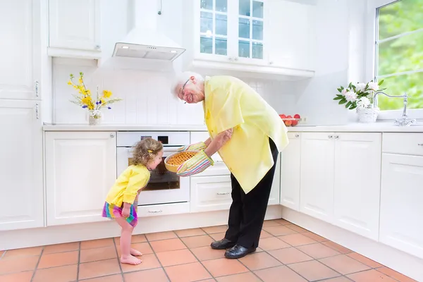 Bonne grand-mère et petite fille faire une tarte dans une kitche blanche — Photo