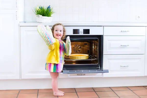 Toddler girl with an apple pie in the oven — Stock Photo, Image