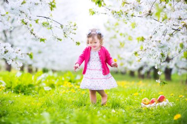 Şirin Bebek kız yeme elma bir çiçek bahçesinde