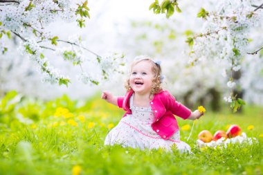 Şirin Bebek kız yeme elma bir çiçek bahçesinde