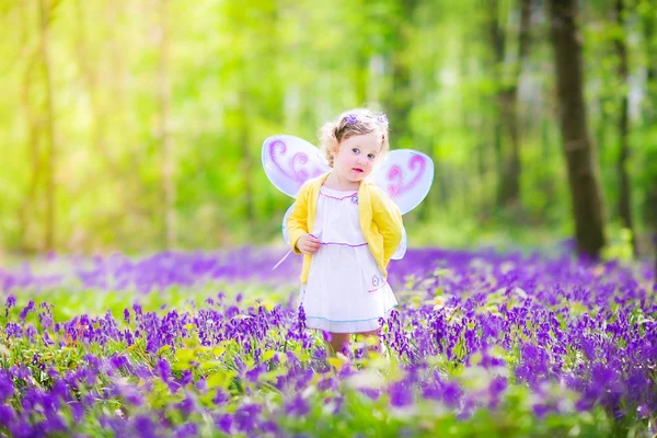 Kisgyermek lány tündér jelmez bluebell erdő — Stock Fotó