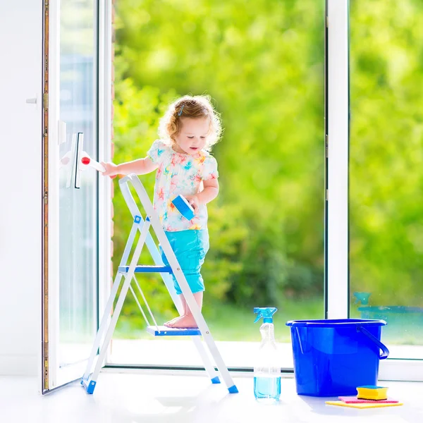 Liten flicka tvätta ett fönster — Stockfoto