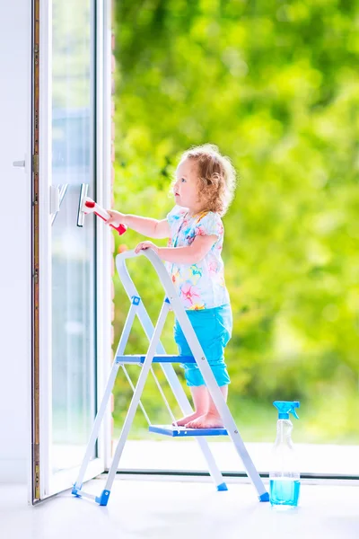 Malá holčička mytí okna — Stock fotografie