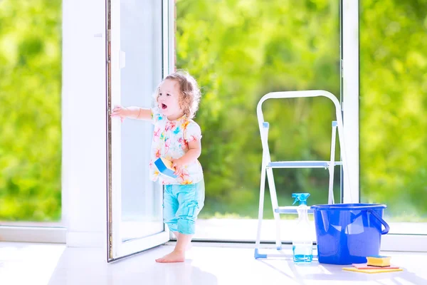 Liten flicka tvätta ett fönster — Stockfoto