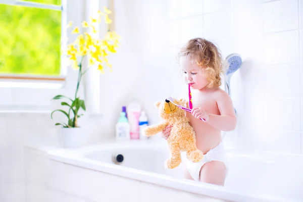 Χαριτωμένο μικρό παιδί κορίτσι βουρτσίζετε τα δόντια με ένα παιχνίδι — Φωτογραφία Αρχείου