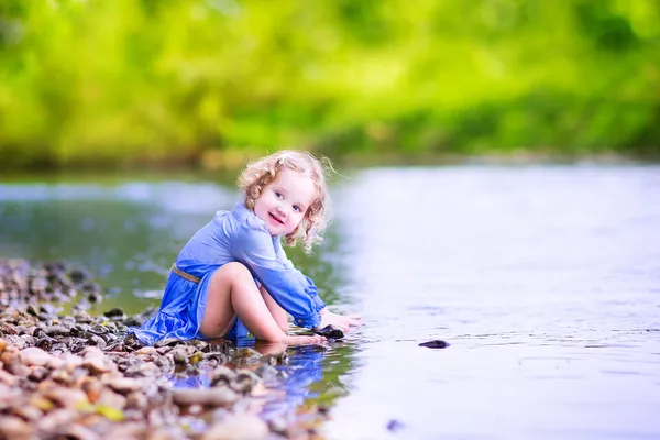 Liten flicka spelar på floden — Stockfoto