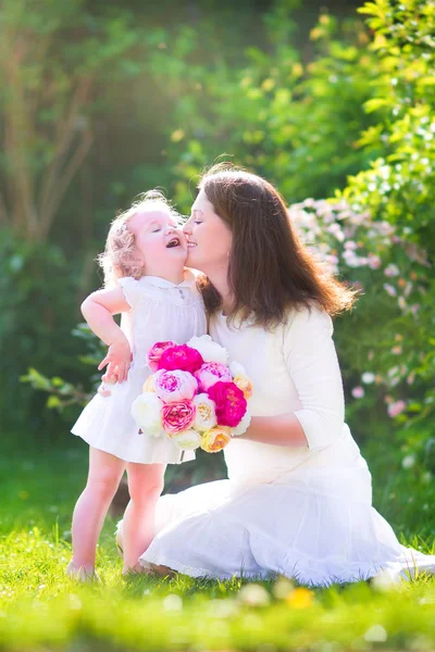 Lycklig mor och hennes dotter i trädgården — Stockfoto