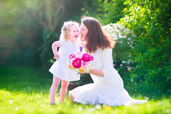 Lycklig mor och hennes dotter i trädgården — Stockfoto