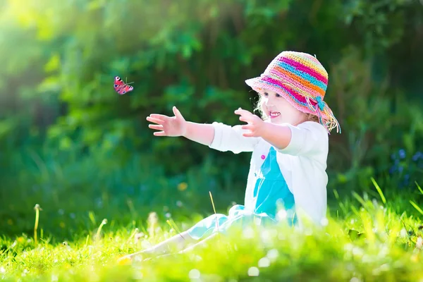 Toddler girl playing with butterfly — Stock Photo, Image