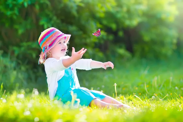 Toddler dziewczynka gra z motyl — Zdjęcie stockowe