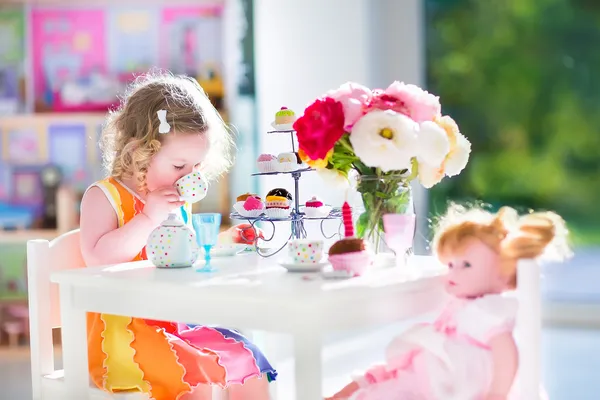 Toddler girl playing tea party with a doll — Stock Photo, Image