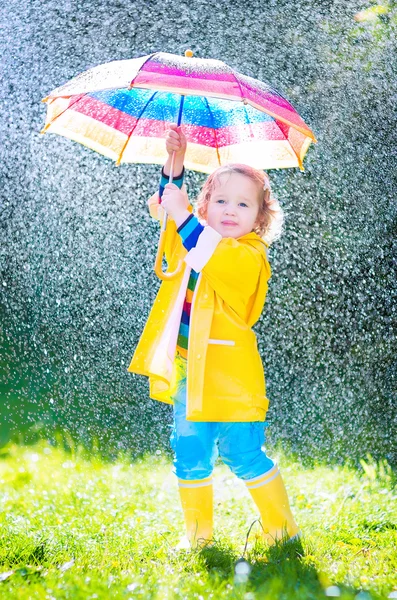 Funny toddler with umbrella playing in the rain — Stock Photo, Image