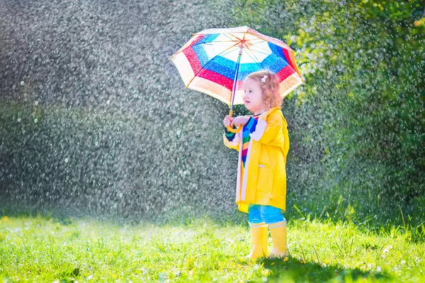 Веселий малюк з парасолькою грає під дощем — стокове фото