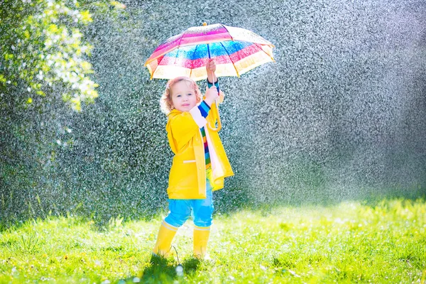 Funny toddler with umbrella playing in the rain — Stock Photo, Image