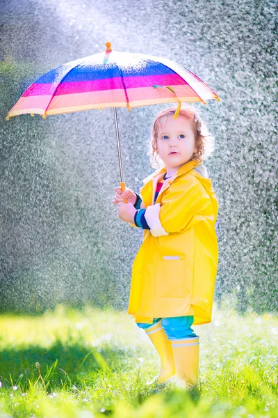 Funny toddler with umbrella playing in the rain — Stock Photo, Image