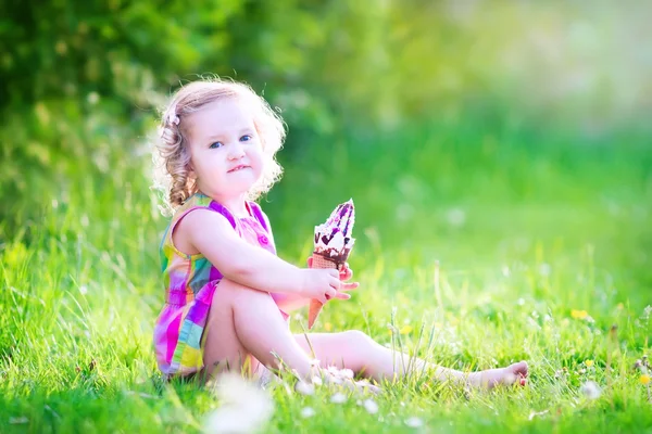 Funny girl eating ice cream in the garden — Stock Photo, Image