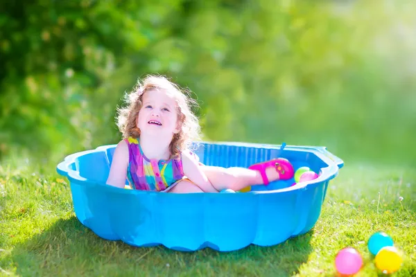 Kisgyermek lány játszik wil golyó a kertben — Stock Fotó