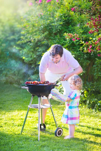 Vader en dochter grillen in de tuin — Stockfoto