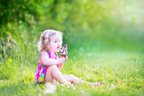 Funny girl eating ice cream in the garden — Stock Photo, Image