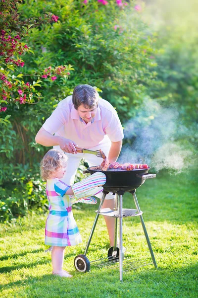 Vader en dochter grillen in de tuin — Stockfoto