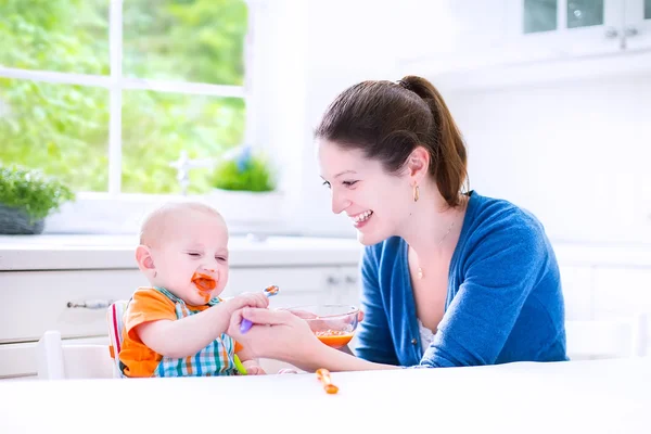 Baby boy eating his first solid food — Stock Photo, Image