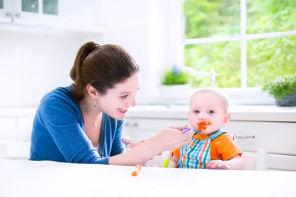 Babyjongen zijn eerste vaste voedsel eten — Stockfoto