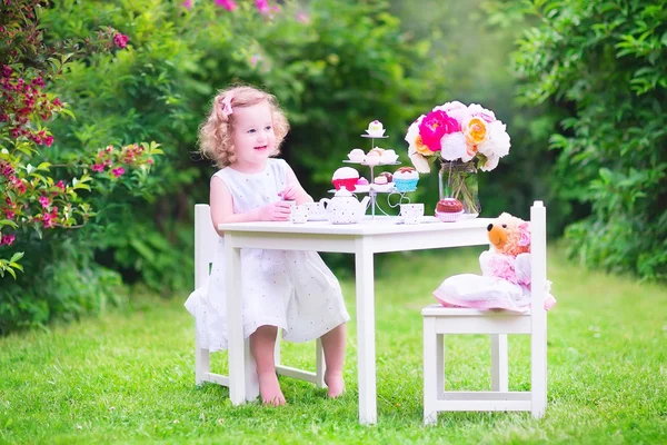 Menina de criança jogando chá festa com uma boneca — Fotografia de Stock