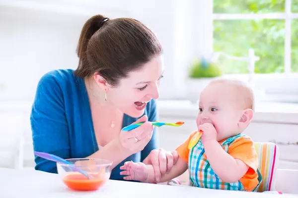 Baby boy eating his first solid food — Stock Photo, Image