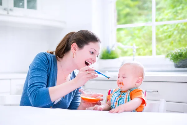 Babyjongen zijn eerste vaste voedsel eten — Stockfoto