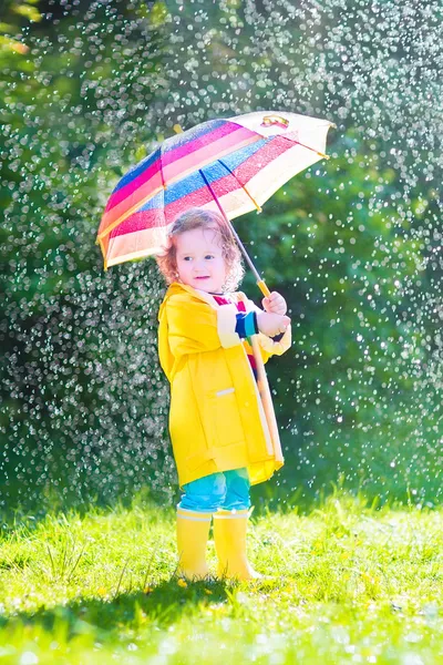 Funny toddler with umbrella playing in the rain — Stock Photo, Image