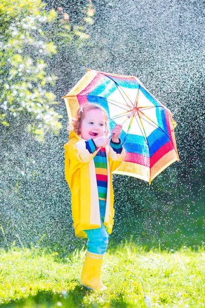 Funny toddler with umbrella playing in the rain — Stock Photo, Image