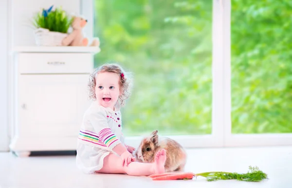 Kleines Mädchen spielt mit einem Hasen — Stockfoto