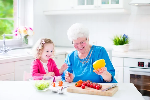 Büyükanne ve küçük kız salatası yapmak Telifsiz Stok Fotoğraflar