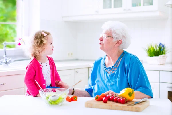 Großmutter und kleines Mädchen machen Salat — Stockfoto