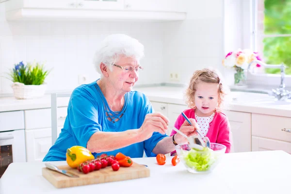 Mormor och liten flicka göra sallad — Stockfoto