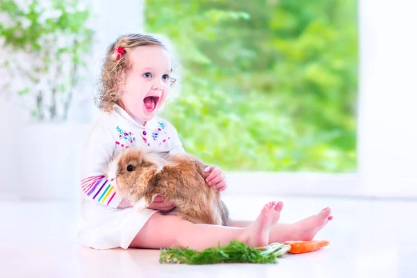 Küçük kız tavşan ile oynama — Stok fotoğraf